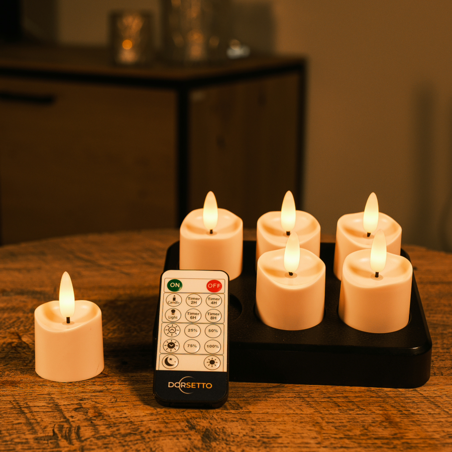 Zes 6 oplaadbare waxinelichtjes, realistisch en met afstandsbediening (175 uur brandtijd), zijn op een zwart dienblad op hout gerangschikt; één kaarsje staat los naast het dienblad.