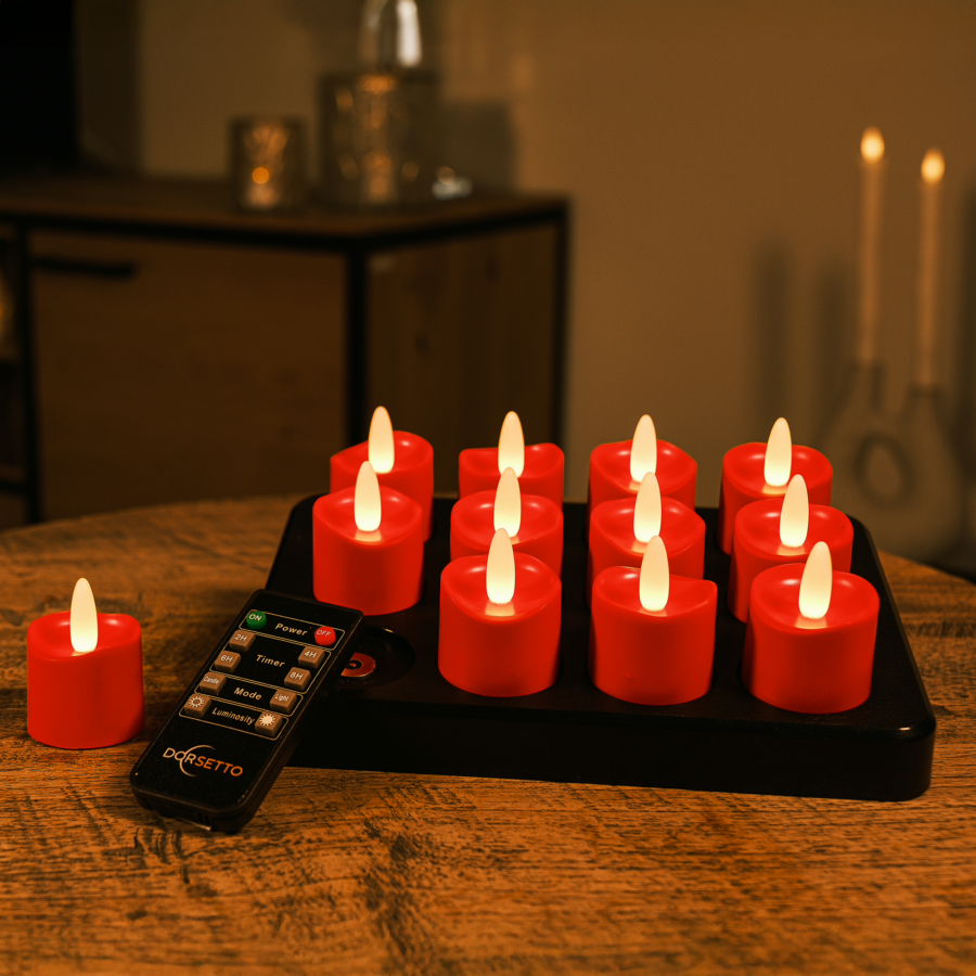 Een zwart dienblad met 12 rode oplaadbare waxinelichtjes led theelichtjes (realistisch, waterdicht, timerfunctie, 175 uur brandtijd) op een houten tafel, met een afstandsbediening ervoor; twee brandende kaarsen gloeien zachtjes in de onscherpe achtergrond.