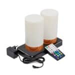 Twee witte houtlook, oplaadbare LED tafellampen (cilindervorm, waterdicht, timerfunctie) staan op een zwart laadpad. Ervoor ligt een afstandsbediening met kleurrijke knoppen en een zwarte AC-adapter.