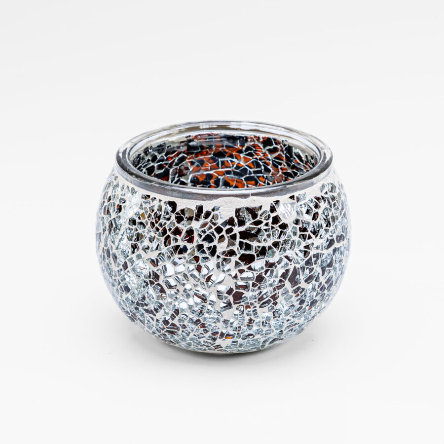 De Theelichthouder zwart 9 CM DORSETTO is een ronde glazen theelichthouder met een zwart mozaïekdesign, voorzien van reflecterende, onregelmatige stukjes glas en een metalen rand. Het glanzende, gefragmenteerde patroon steekt af tegen een effen witte achtergrond.