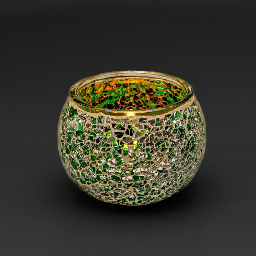 Theelichthouder DORSETTO 9 cm donker groen: een ronde glazen kandelaar met een mozaïek van groene en gouden reflecterende stukjes, afgebeeld tegen een effen zwarte achtergrond.