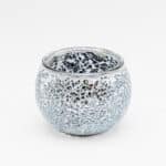 De Theelichthouder zwart 9 CM DORSETTO is een ronde glazen theelichthouder met een zilveren mozaïekpatroon en reflecterende, gebarsten glazen stukjes op het oppervlak, tegen een effen witte achtergrond.