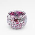 Theelichthouder 9 cm DORSETTO paars: een ronde glazen waxinelichthouder met een mozaïek van glanzende, onregelmatige zilveren en roze stukjes, afgebeeld op een effen witte achtergrond.