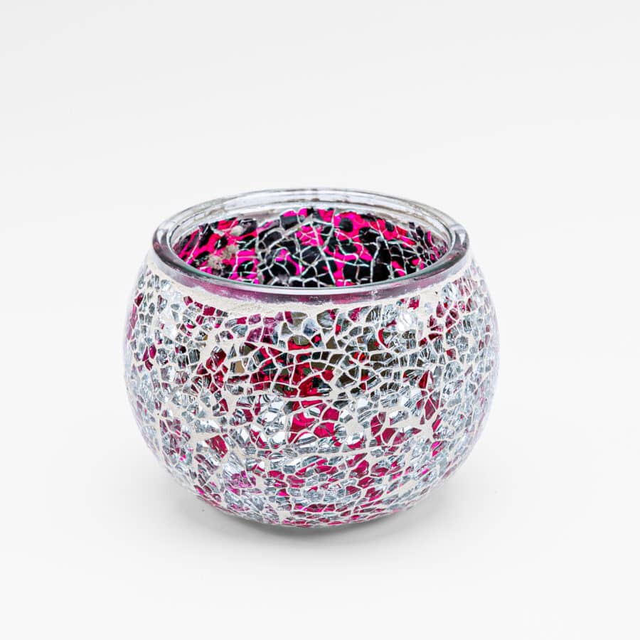 Theelichthouder 9 cm DORSETTO paars: een ronde glazen waxinelichthouder met een mozaïek van glanzende, onregelmatige zilveren en roze stukjes, afgebeeld op een effen witte achtergrond.