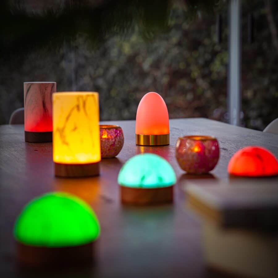 Een 1 oplaadbare LED tafellamp met bolvorm, waterdicht ontwerp, timerfunctie en wit marmer-hout look staat op een houten tafel en zorgt voor een gezellige, sfeervolle uitstraling. De achtergrond is zacht onscherp.