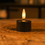 De Led waxinelichtjes Off-Black No.57 zwart gloeit warm met een realistisch vlameffect op hout en gaat tot 175 uur mee - perfect voor wie op zoek is naar langdurige, warme witte LED kaarsen voor een gezellige sfeer.