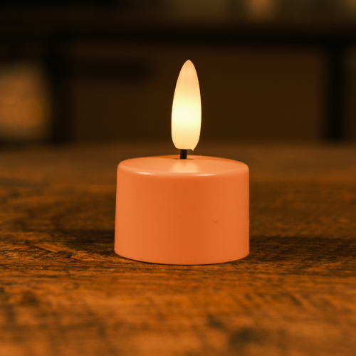 Een blushroze Oplaadbaar waxinelichtje los 175 uur met warm wit licht en een realistisch vlameffect zit op hout en werpt een gezellige gloed in de zacht vervaagde achtergrond.