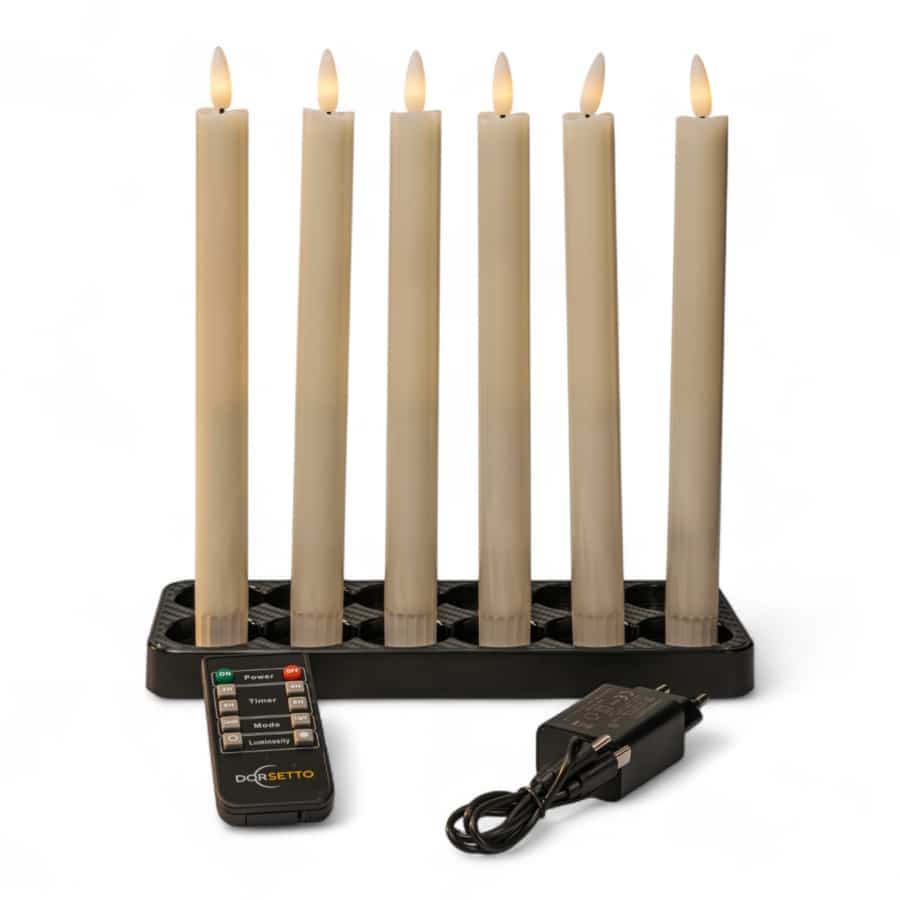 Zes donkergrijze Dinerkaarsen LED kaarsen (set van 6), oplaadbaar met een brandtijd tot 400 uur, staan verticaal in een zwarte houder. Een afstandsbediening en stroomadapter staan vooraan op een witte achtergrond.