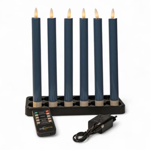 Een set van 6 led dinerkaarsen LED donker grijs, oplaadbare kaarsen met tot 400 uur merkduur, staat rechtop in een zwarte rechthoekige houder. Een afstandsbediening en oplader liggen ervoor op een witte achtergrond.