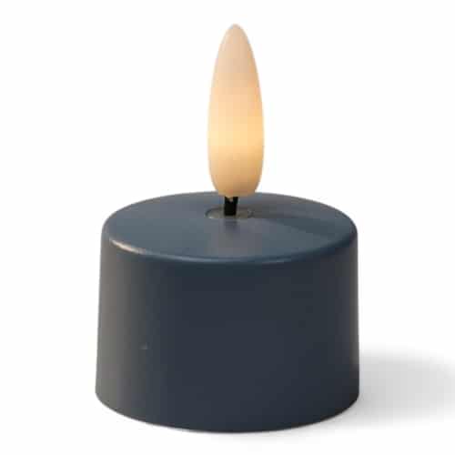 Een klein, donkerblauw, cilindervormig LED waxinelichtje met een realistisch, vlamvormig licht bovenop, tegen een witte achtergrond.