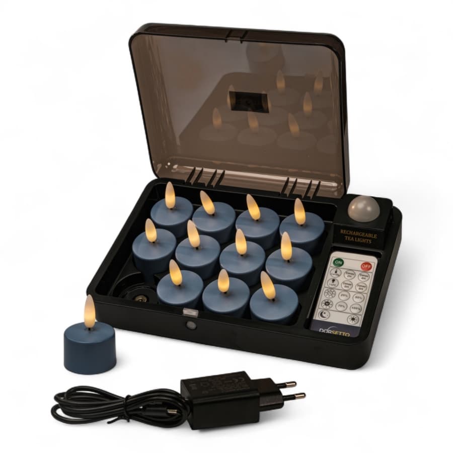 De Led waxinelichtjes Stone Bleu No.86 set bevat 12 blauwe oplaadbare theelichtjes (tot 400 uur per stuk), een zwart oplaaddoosje, afstandsbediening en voedingsadapter; één theelichtje is afgebeeld buiten het doosje.