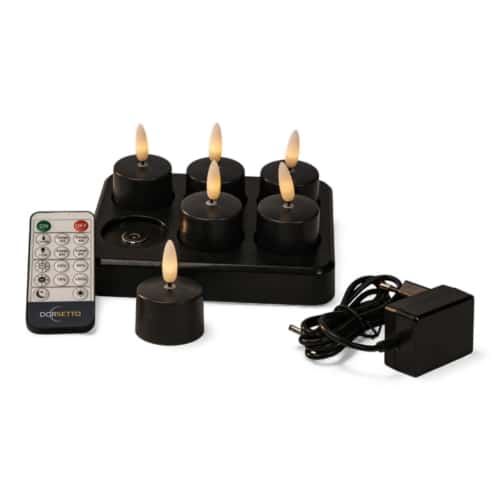 Een set van zes zwarte LED waxinelichtjes met vlamvormige lampjes, een zwarte oplaadbasis, een afstandsbediening en een voedingsadapter, allemaal weergegeven op een witte achtergrond.